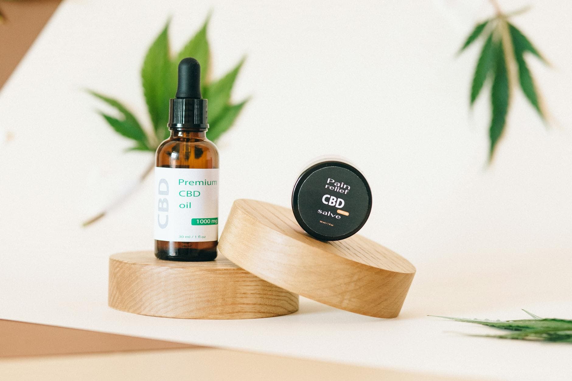 Skincare products including CBD oil and balm on wooden surface